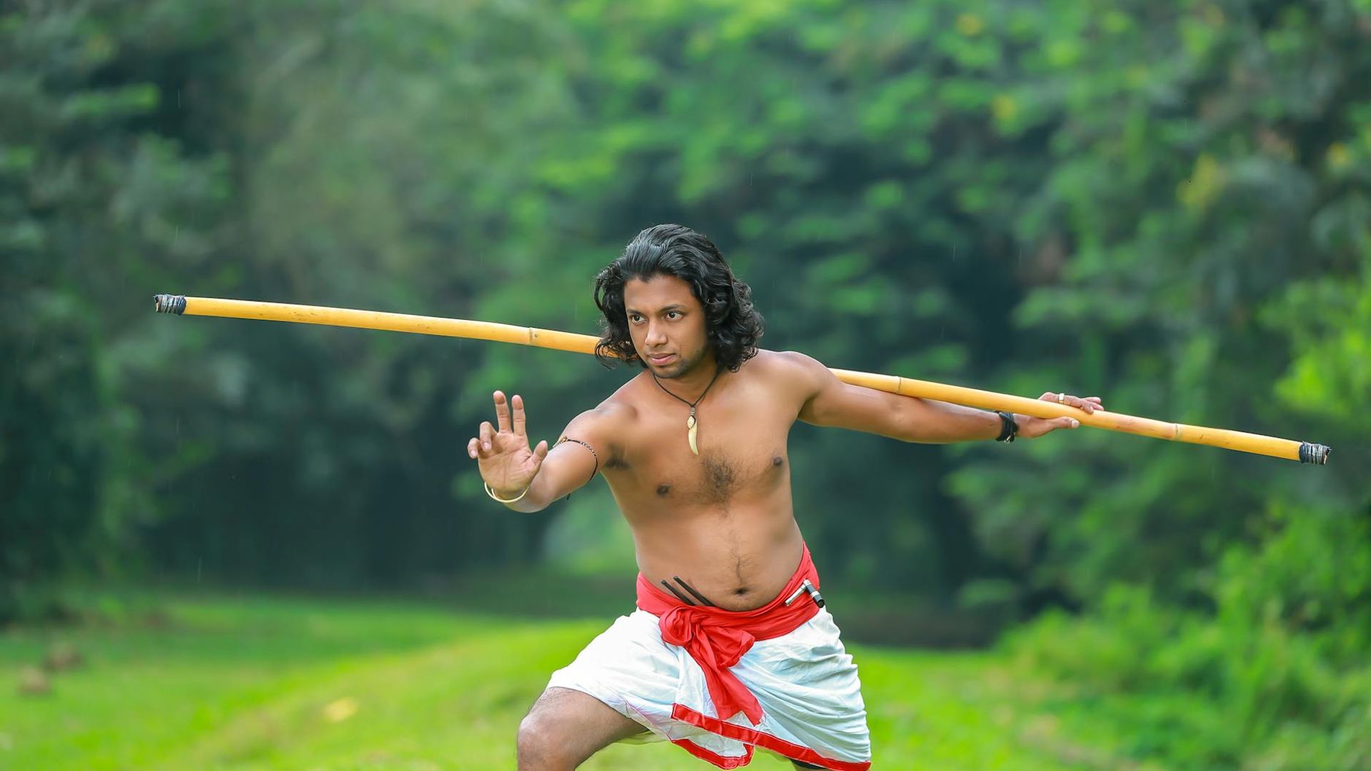 Man performing a controlled strength exercise in a dark, focused environment.